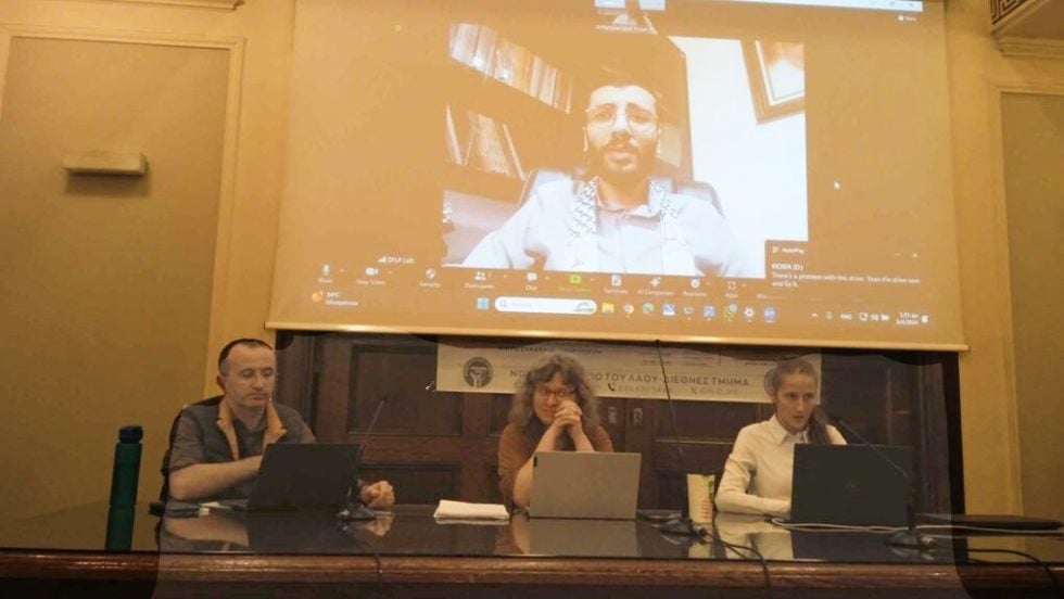 Από αριστερά: Γκιουνάι Νταγκ, Ευγενία Κουνιάκη, Κωνσταντίνα Καρτσιώτη (μέλος του Λαϊκού Μετώπου και συντονίστρια). Στη γιγαντοοθόνη ο Παλαιστίνιος δικηγόρος Φουάντ Μπακέρ